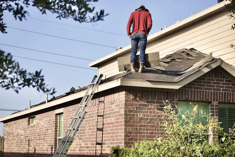 Professional roofer working on a residential roof in Monclair